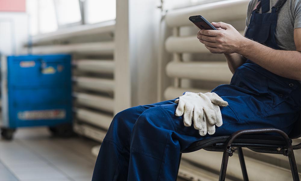 Tecnico che utilizza il telefono per richiedere assistenza &ndash; Contatti Chiama Spurgo a Roma